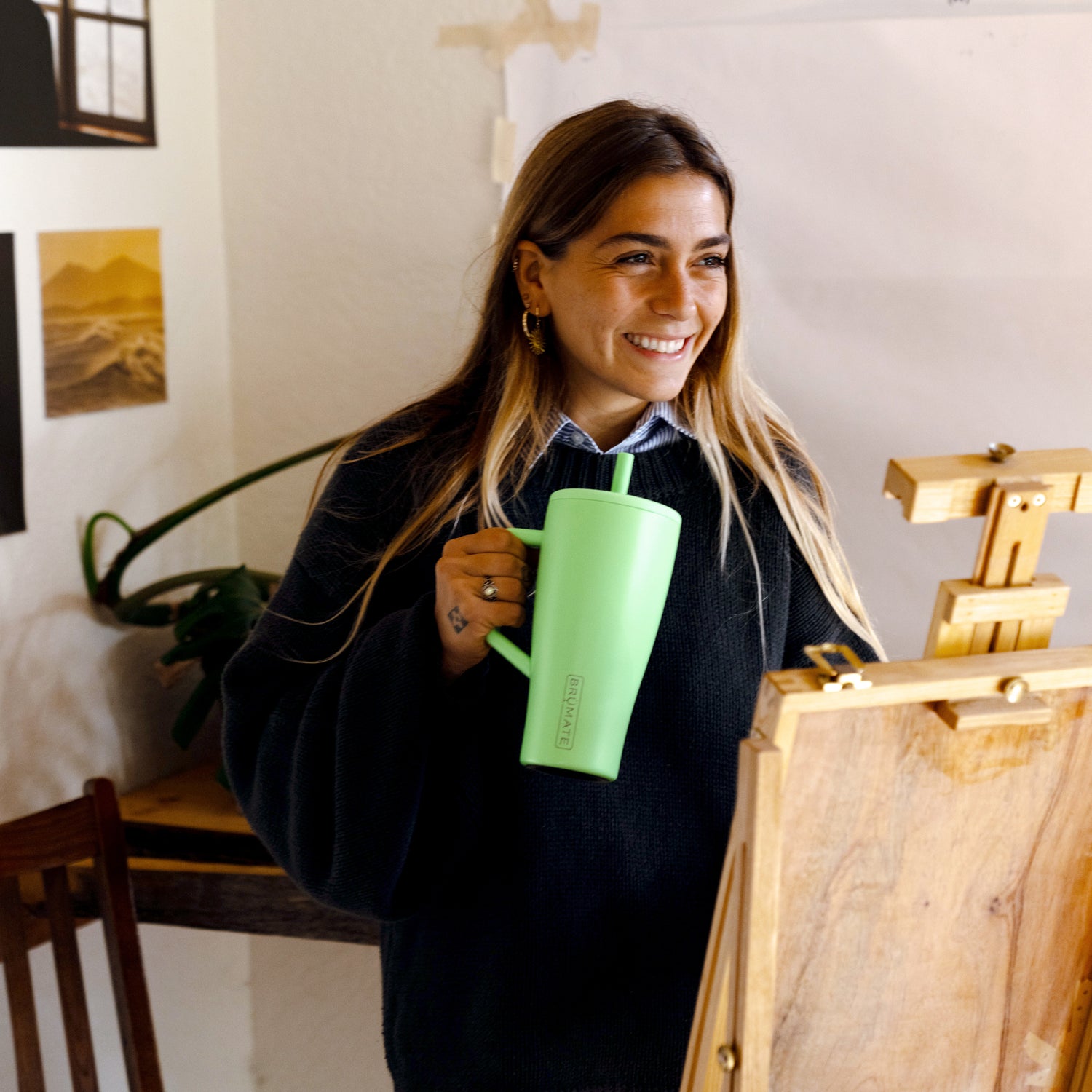 Woman holding a green Era 30oz straw tumbler indoors
