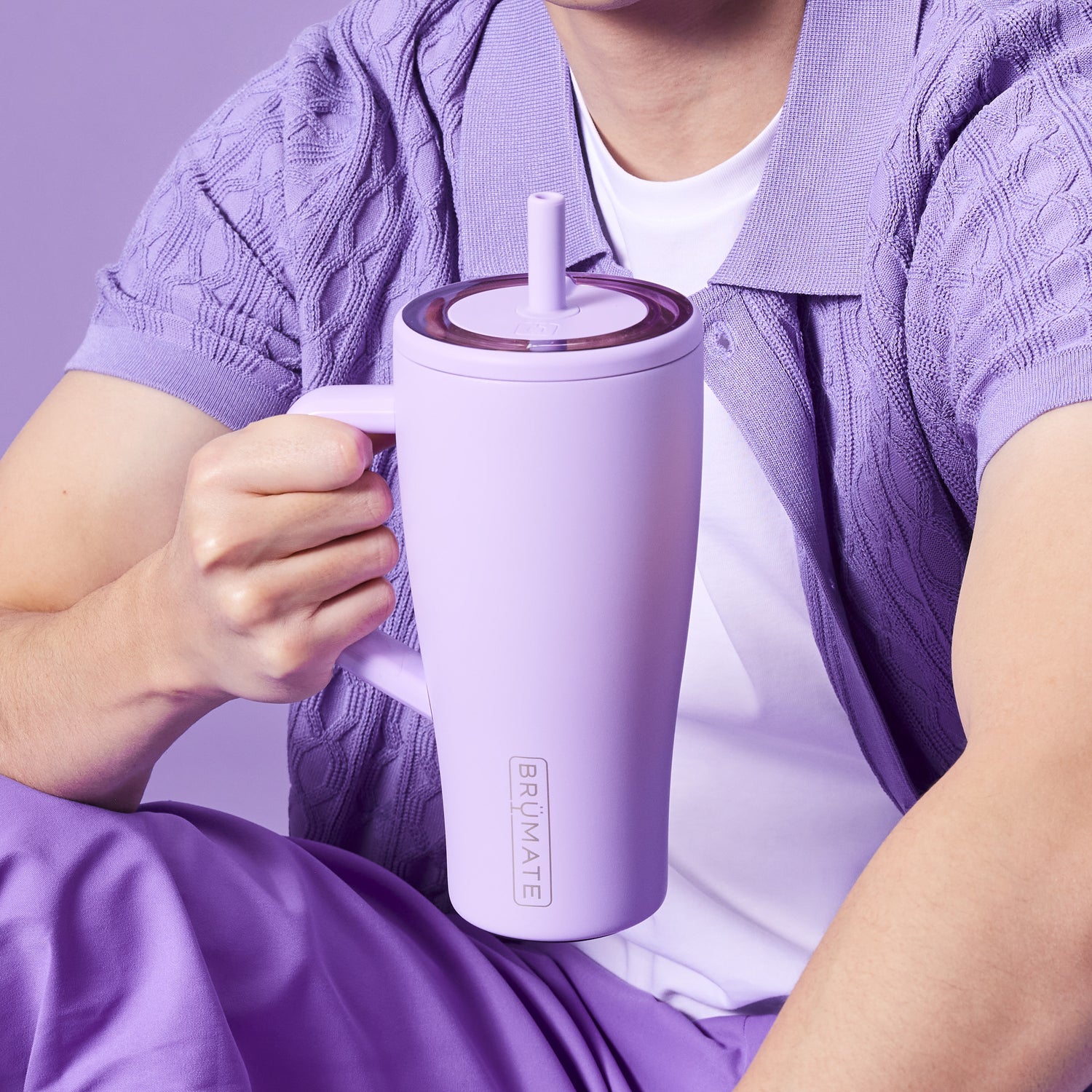 Person holding a purple BruMate ERa 30oz tumbler against a matching purple background