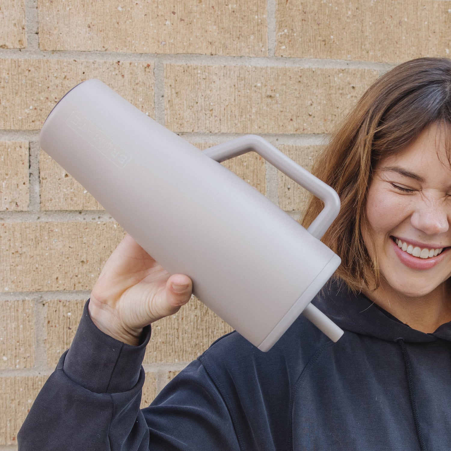 Person holding a beige Era 40oz tumbler upside down.