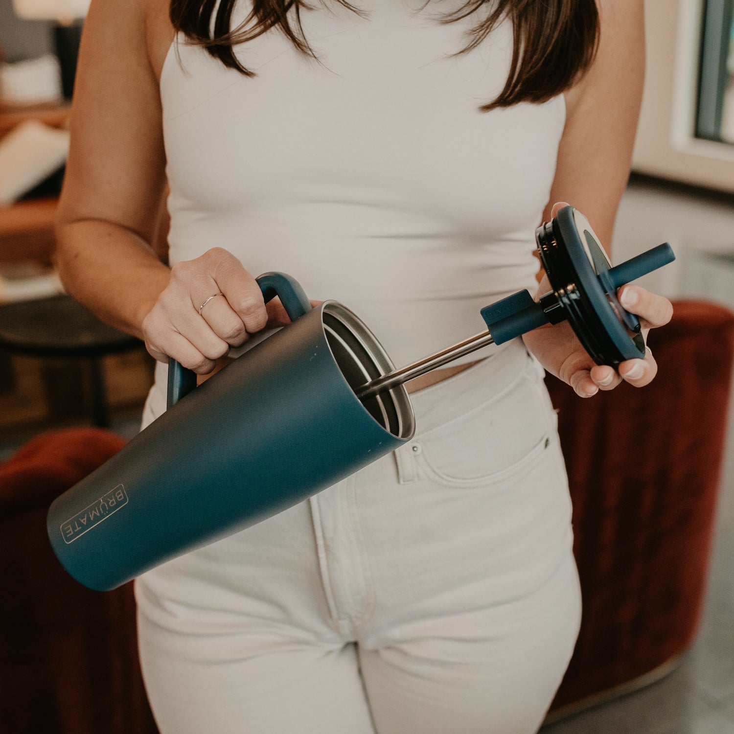 Person holding a blue Era 40oz tumbler whilst removing the lid and straw
