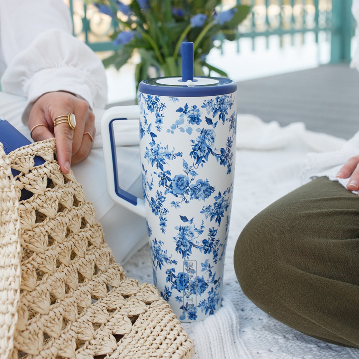 Person holding a blue and white floral-patterned Era 40oz tumbler outdoors