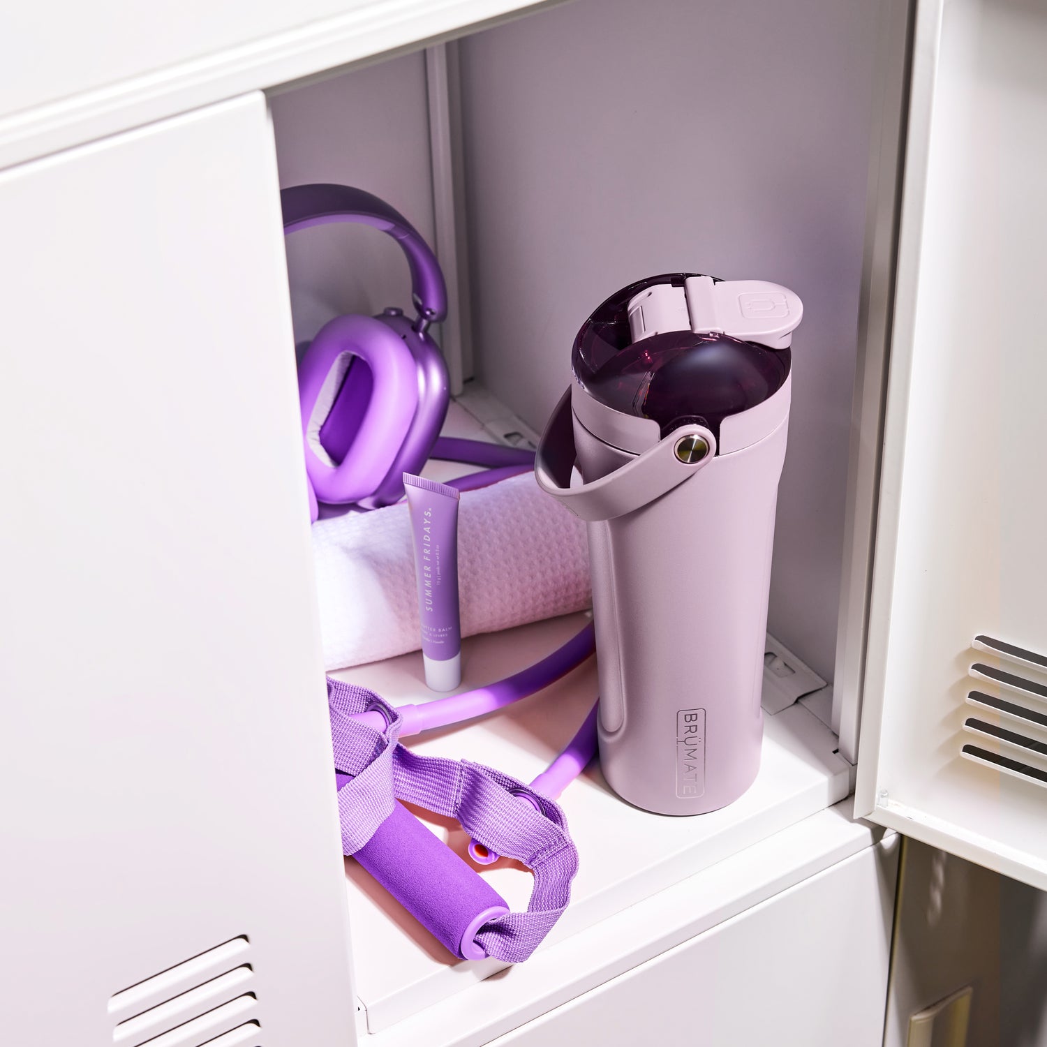 Purple MultiShaker 25oz Fitness Shaker with exercise equipment in a locker