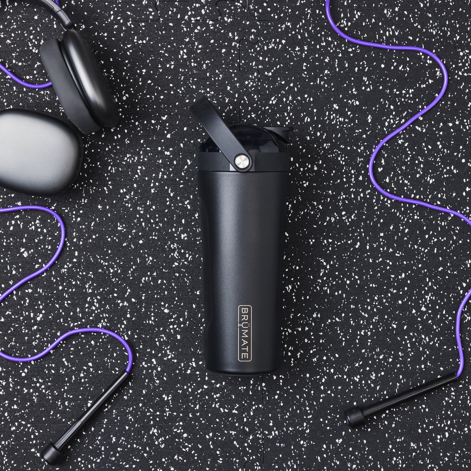 Black MultiShaker 25oz Fitness Shaker with 'BruMate' branding on a black speckled background with purple accents.