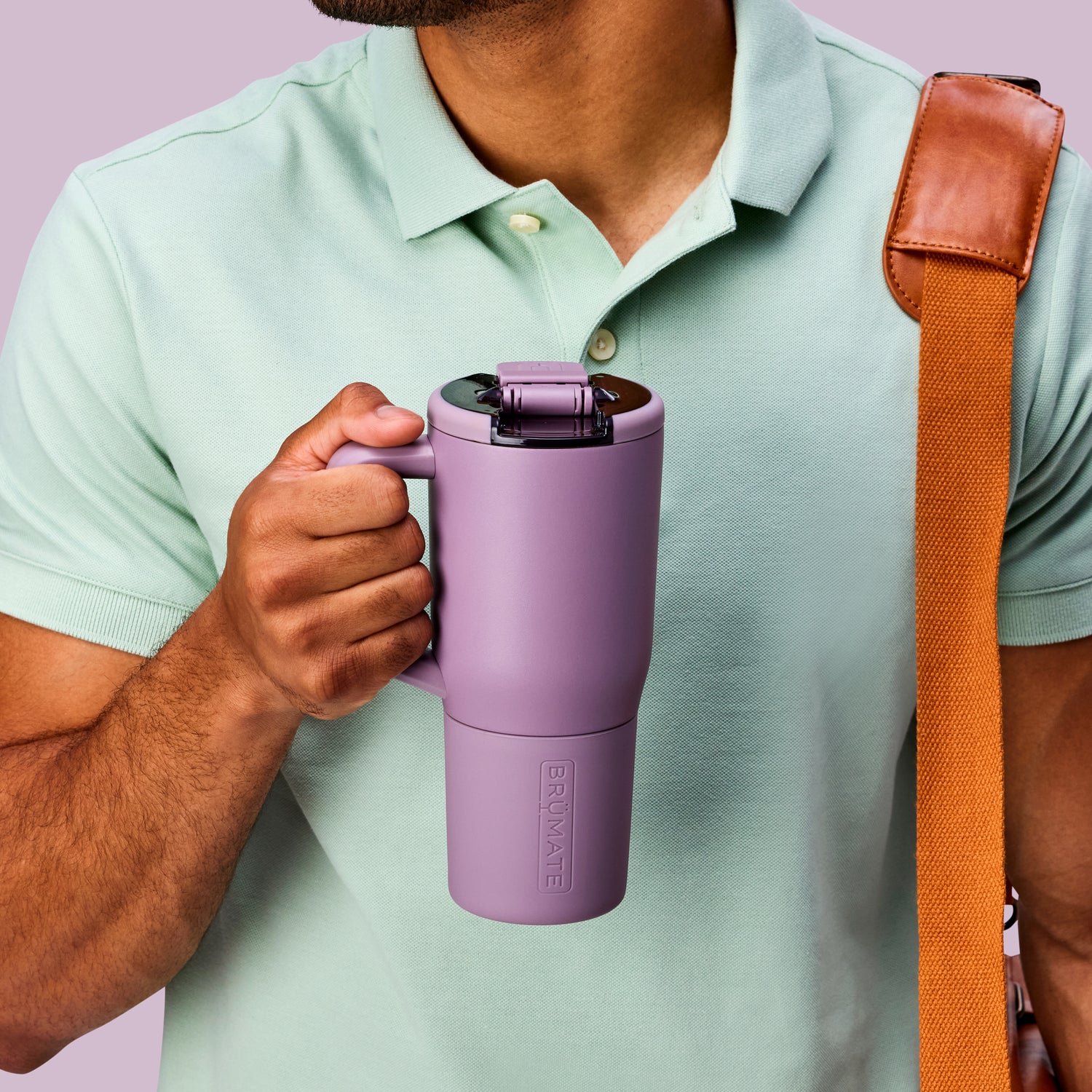 Person holding a purple Muv 25oz mug with a brown strap over shoulder against a light purple background