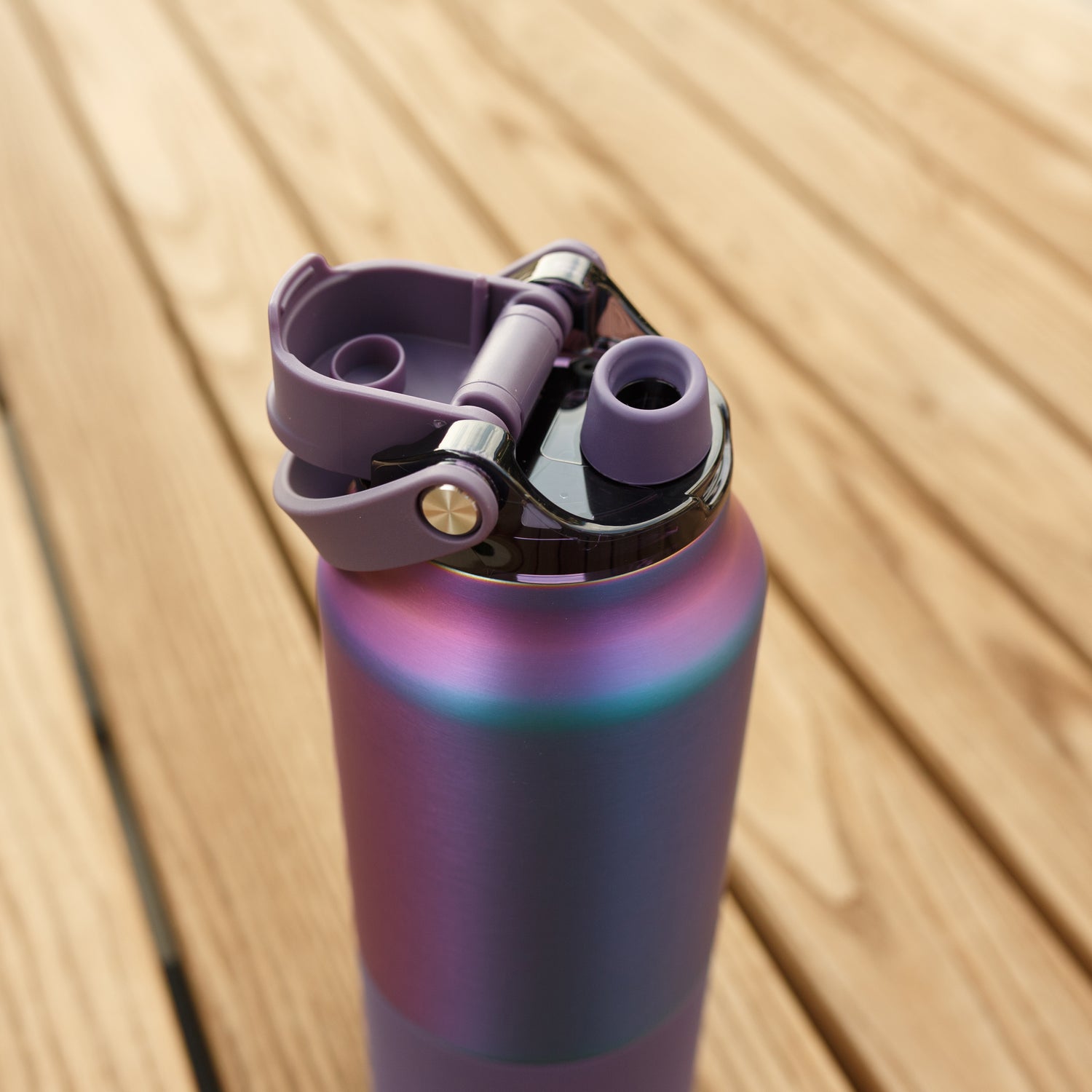 Gradient purple Rise 25oz water bottle  with a cap on a wooden surface
