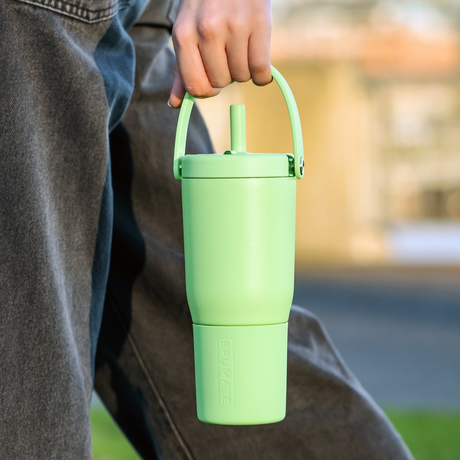 Person holding a green Resa 35oz tumbler with a blurred background