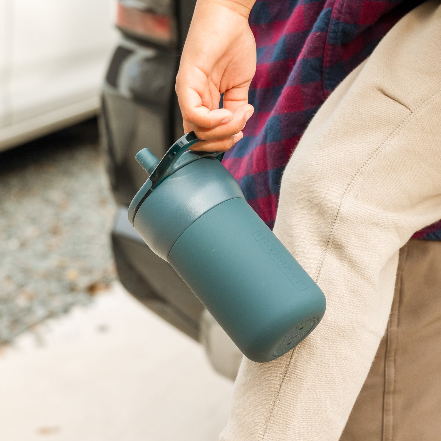 Person holding a blue Leap 12oz tumbler outdoors with a car in the background